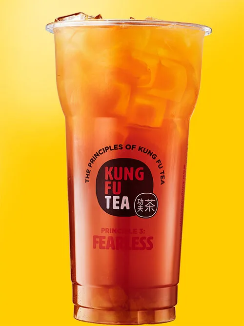 Iced fruit tea with fruit pieces in a Kung Fu Tea branded cup.